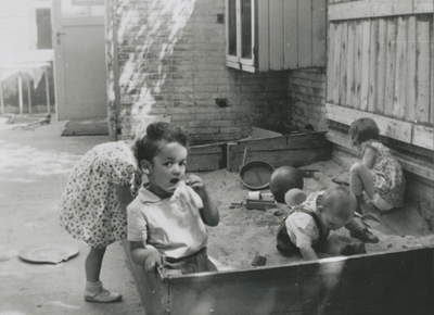 876973 Afbeelding van enkele kleuters die spelen in een zandbak op de binnenplaats van het opvanghuis 'Meisjesstad' ...